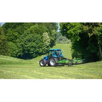 Text: LS tractor and Hofman rake on the meadow